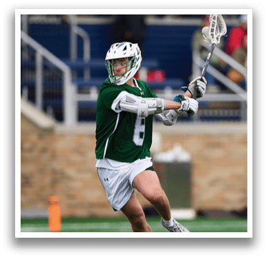A man wearing a green and white shirt and white shorts is running on a field. Description generated by AI