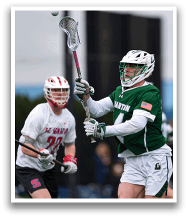 A man holding a lacrosse stick. Description generated by AI