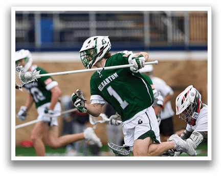 A man wearing a green jersey with the number 14 on it is running with a lacrosse stick. Description generated by AI