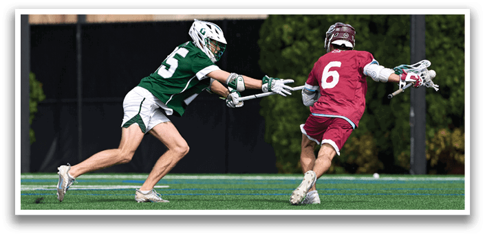Two men playing lacrosse on a field. Description generated by AI