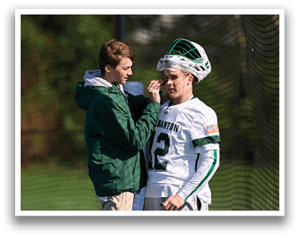 A man is adjusting a helmet on another man. Description generated by AI