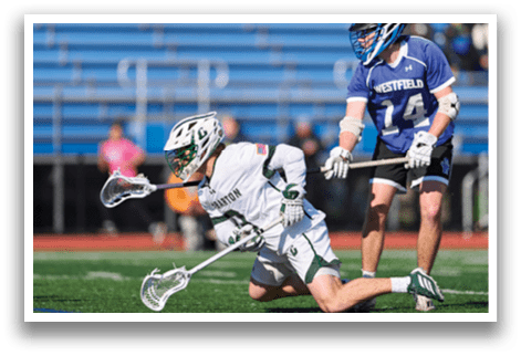 A man is playing lacrosse and is on the ground. Description generated by AI