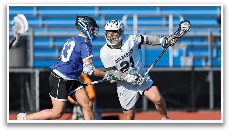 Two men playing lacrosse on a field. Description generated by AI
