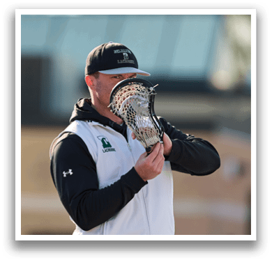 A man holding a lacrosse net. Description generated by AI