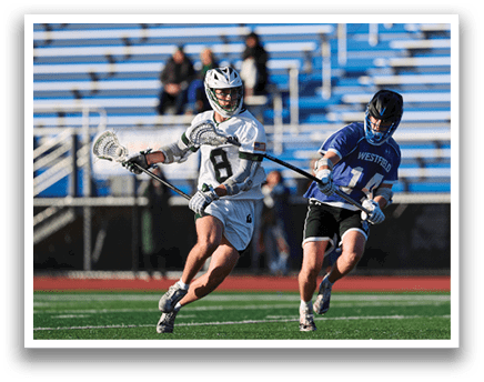 Two men playing lacrosse on a field. Description generated by AI