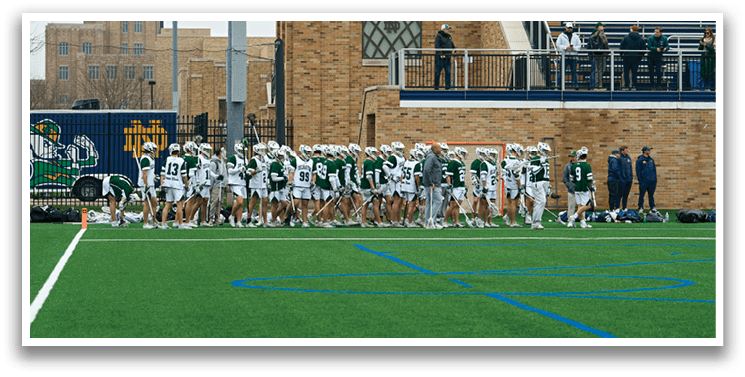 A group of people in green and white uniforms are standing on a field. Description generated by AI
