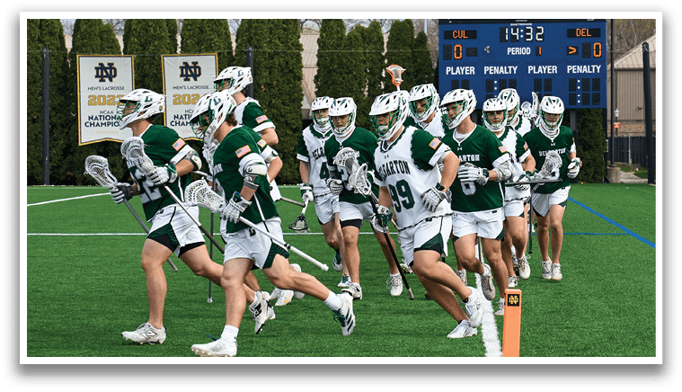 A group of people wearing green and white uniforms are running on a field. Description generated by AI