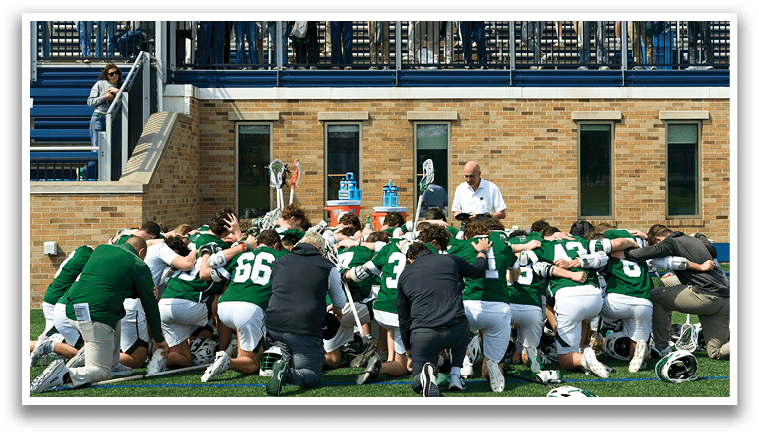 A group of football players kneeling on the field. Description generated by AI