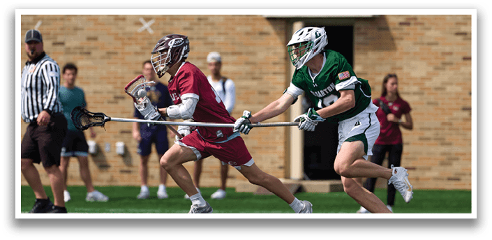 A man in a red shirt is running with a lacrosse stick. Description generated by AI