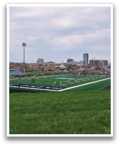 A green field with a blue line on it. Description generated by AI