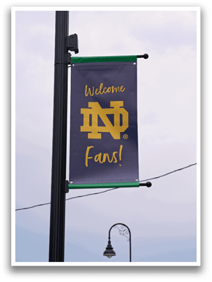 A banner on a pole welcoming fans to a sports event. Description generated by AI