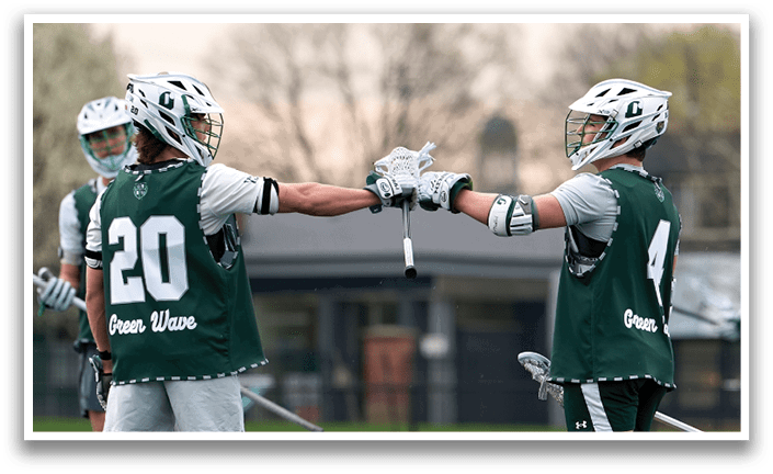 Two men wearing green jerseys shake hands. Description generated by AI