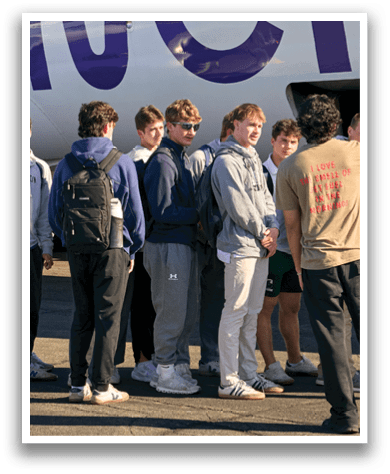 A group of people standing on the tarmac. Description generated by AI