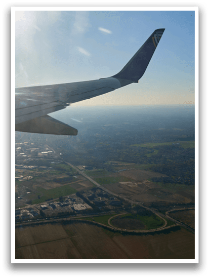 A plane wing with sunlight shining on it. Description generated by AI
