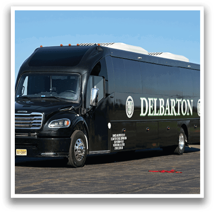 A black Delmarion bus is parked next to a white airplane. Description generated by AI