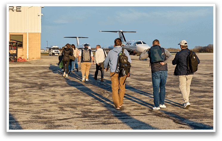 A group of people walking on a tarmac. Description generated by AI