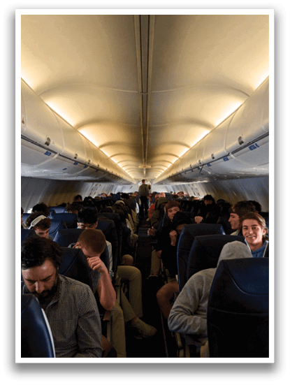 A group of people are sitting in a plane. Description generated by AI