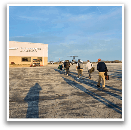 A group of people walking on a tarmac. Description generated by AI