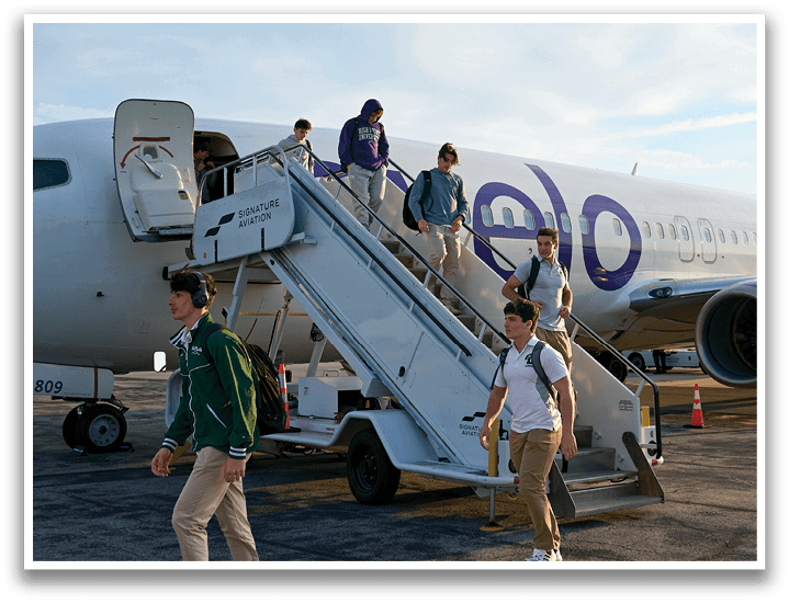 A group of people are walking up a staircase to board a plane. Description generated by AI