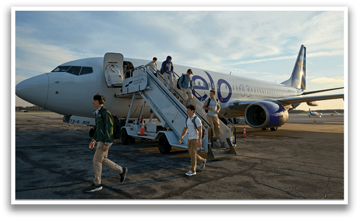 A group of people are walking up a staircase to board a plane. Description generated by AI