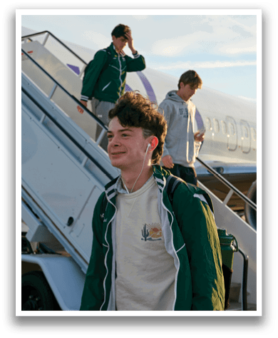 A man wearing a green jacket and headphones. Description generated by AI