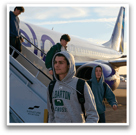 A group of people are walking up a stairway to a plane. Description generated by AI