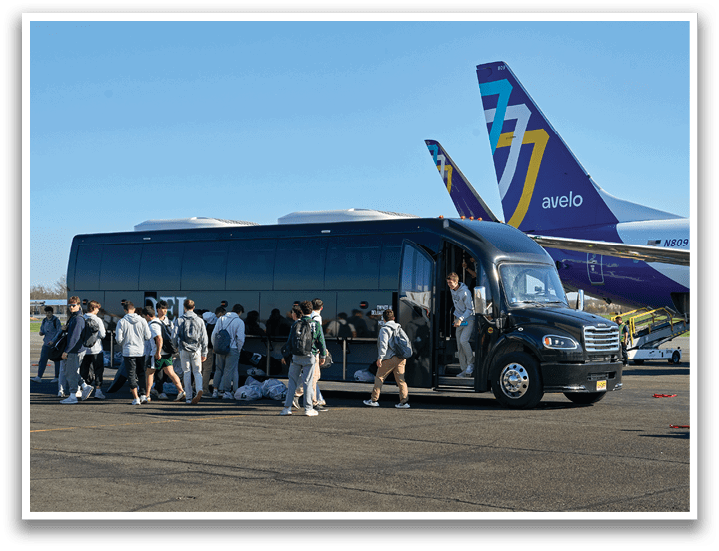 A group of people are standing in front of a bus. Description generated by AI