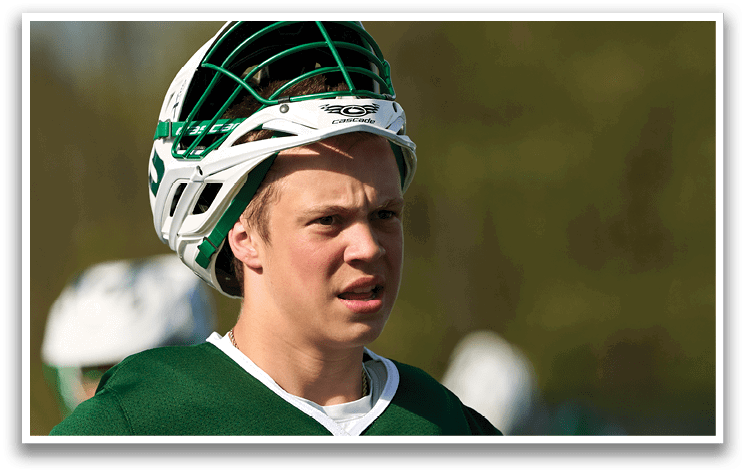 A young man wearing a green and white baseball helmet. Description generated by AI
