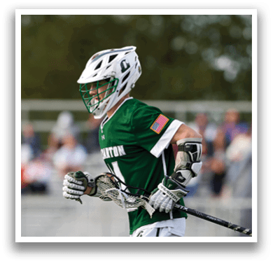 A man wearing a green and white jersey is running with a hockey stick. Description generated by AI