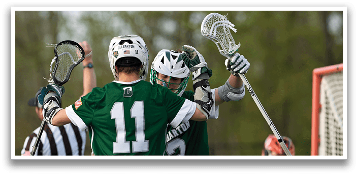 Two men in green jerseys are hugging each other. Description generated by AI
