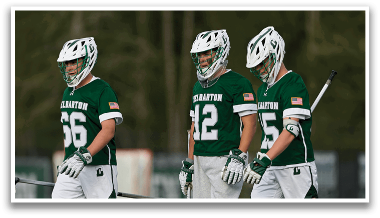 Three men wearing green and white uniforms are walking on a field. Description generated by AI