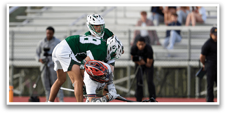 Two men playing a game of lacrosse. Description generated by AI