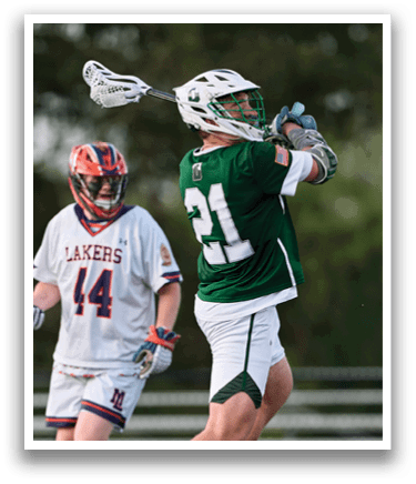 A man in a green jersey is holding a lacrosse stick. Description generated by AI
