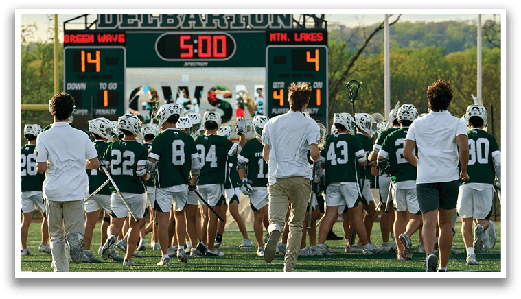 A group of people are on a field with a scoreboard. Description generated by AI