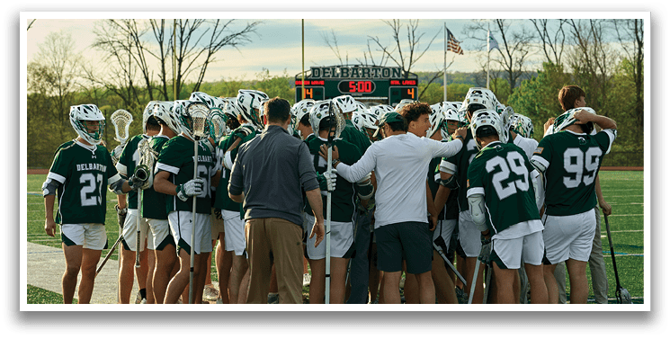 A group of people in green and white uniforms standing on a field. Description generated by AI