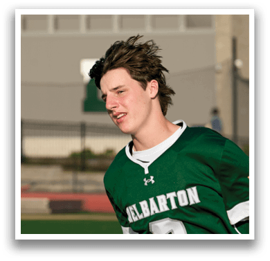 A boy wearing a green jersey with the number 2 on it. Description generated by AI