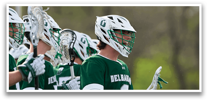 A group of lacrosse players wearing green and white uniforms. Description generated by AI