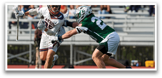 Two men playing lacrosse on a field. Description generated by AI