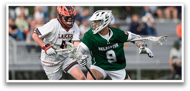 A man wearing a green shirt and white shorts is running with a lacrosse stick. Description generated by AI