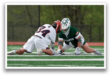 Two men playing football on a field. Description generated by AI