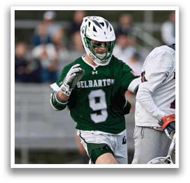 Two men playing lacrosse on a field. Description generated by AI