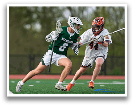 Two men playing lacrosse on a field. Description generated by AI