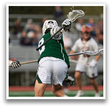 Two men playing lacrosse on a field. Description generated by AI