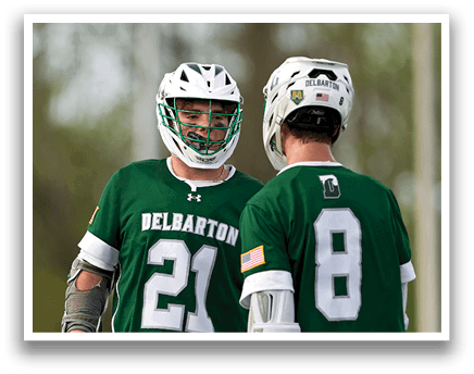 Two men wearing green jerseys and white shorts. Description generated by AI