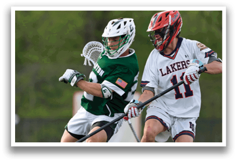 Two men playing lacrosse on a field. Description generated by AI