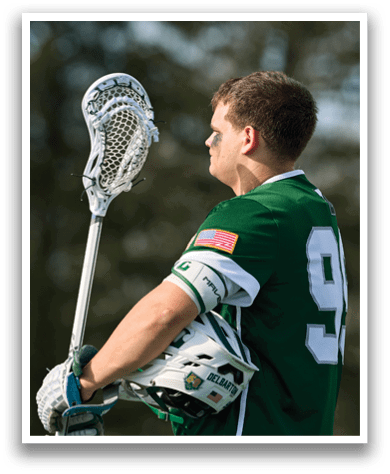 A man holding a lacrosse stick. Description generated by AI