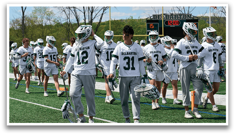 A group of people wearing white uniforms and holding hockey sticks. Description generated by AI