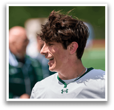 A man with a green necklace smiling. Description generated by AI