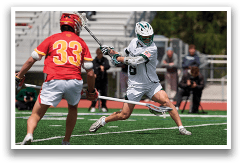 A man in a green and white uniform is swinging a lacrosse stick. Description generated by AI