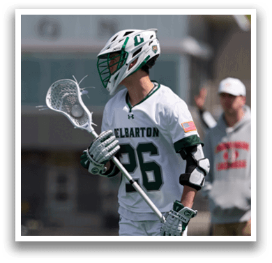 A man wearing a helmet and holding a lacrosse stick. Description generated by AI